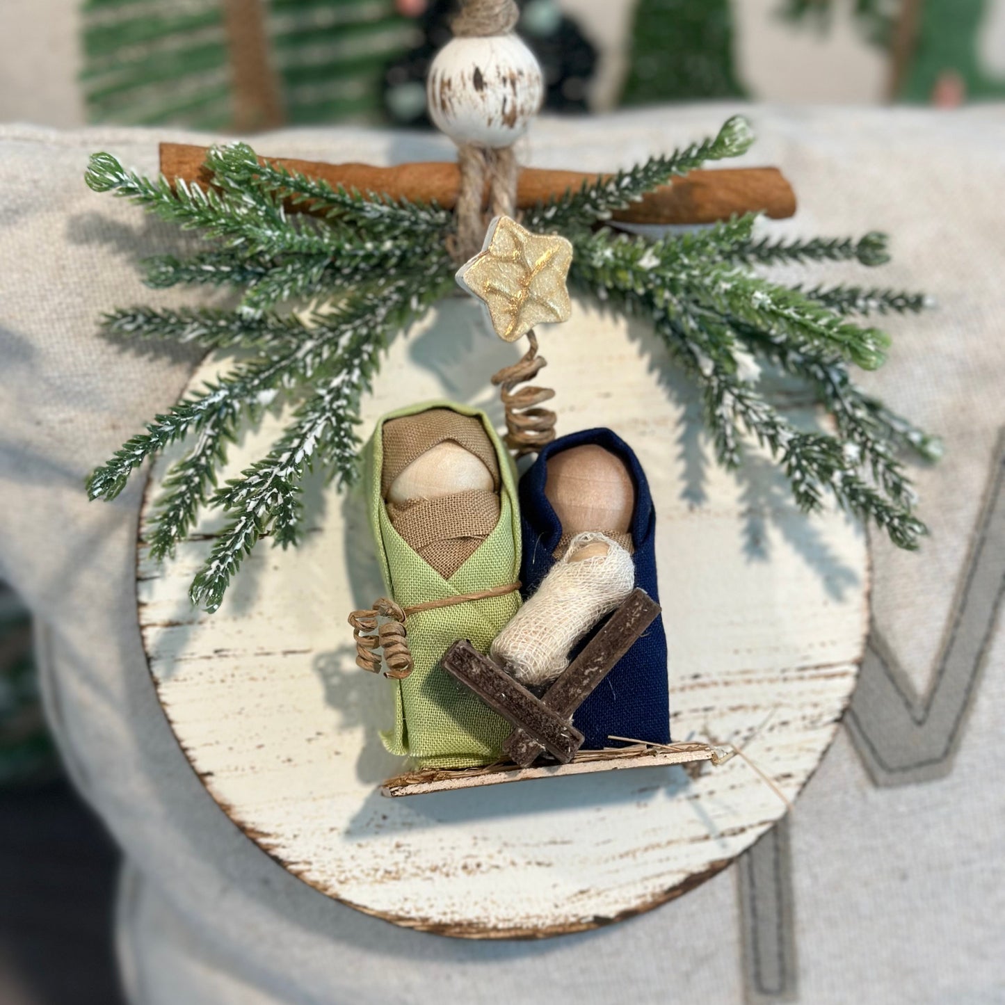 Decorative ornament with a nativity scene and greenery on a rustic background